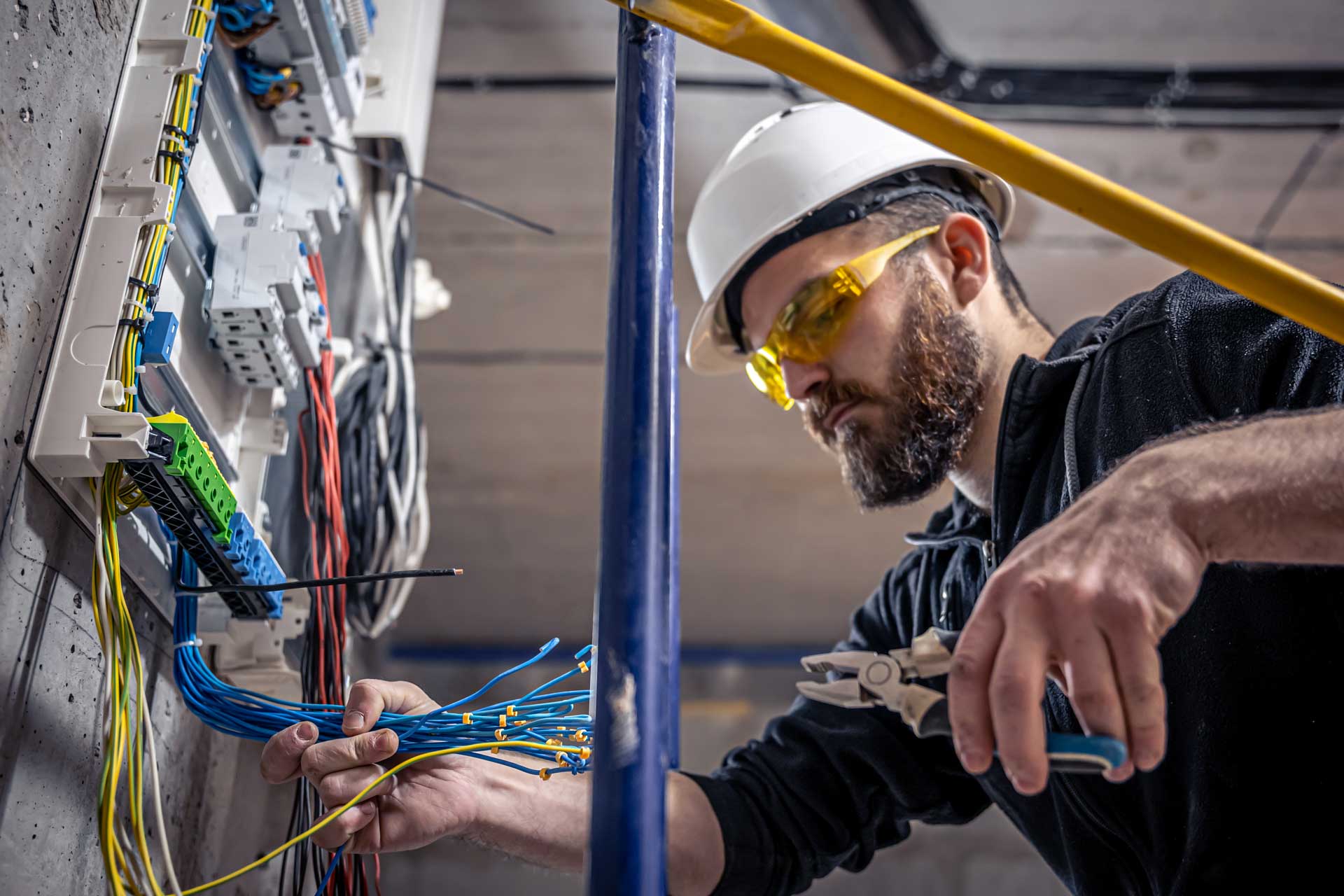 a person in a hard hat working with wires